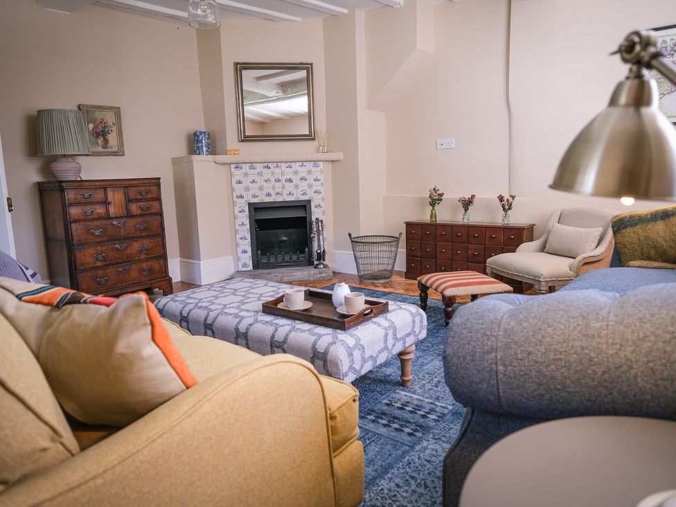 A living room with a fireplace and furniture at Challens Yarde in Midhurst
