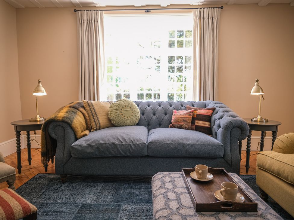 A living room with a blue sofa and coffee table at Challens Yarde in Midhurst
