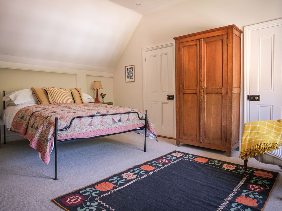 A bedroom with a bed and a wardrobe at Challens Yarde in Midhurst