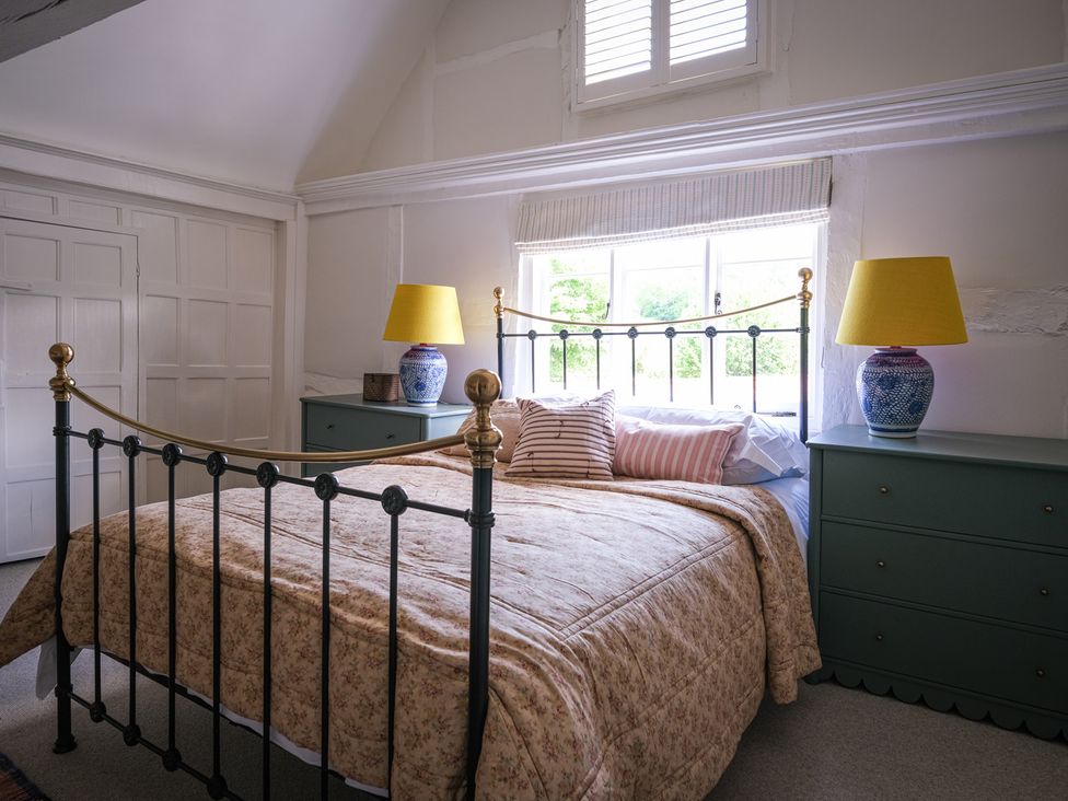 A bedroom with a bed and lamp at Challens Yarde in Midhurst