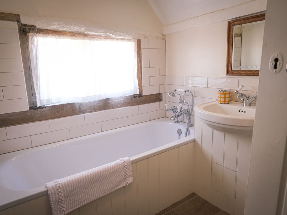 A bathroom with a bathtub and sink at Challens Yarde in Midhurst