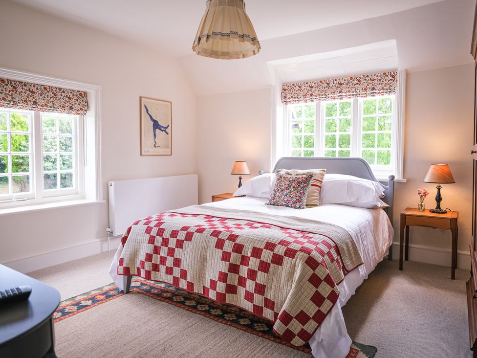 A bedroom with a bed and windows at Challens Yarde in Midhurst