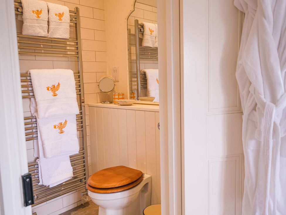 A bathroom with towels on a rack and a toilet at Challens Yarde in Midhurst