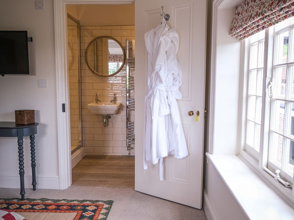 A bathroom with a small sink and mirror at Challens Yarde in Midhurst