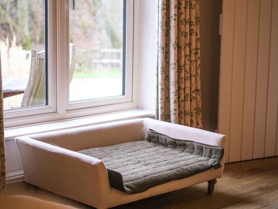 A pet bed near a window in a living room at Broomhill cottage Petworth