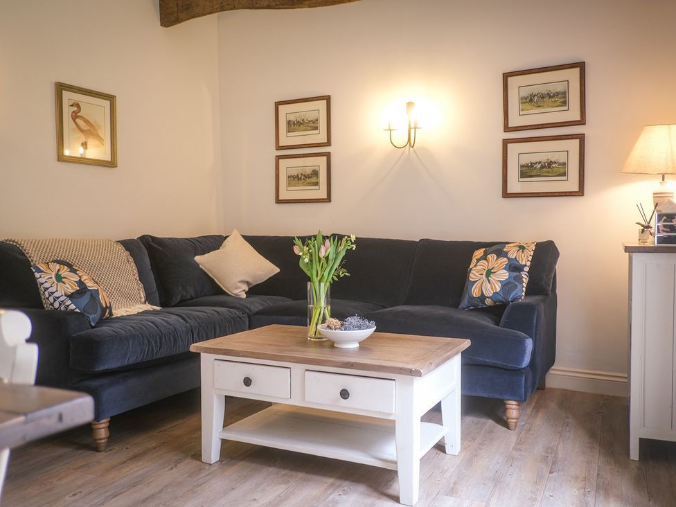 A living room with a sofa and coffee table at Oaters Wood, Petworth