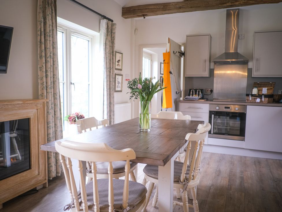 A kitchen with a table and chairs at Oaters Wood Petworth