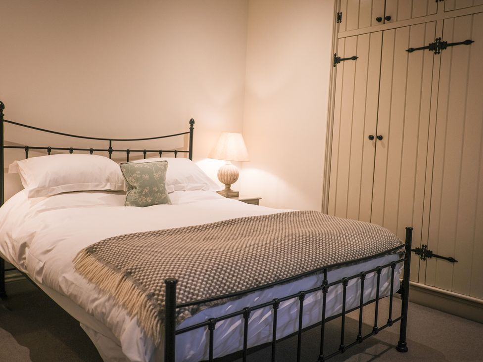 A bedroom with a bed and a wardrobe at Oaters Wood in Petworth