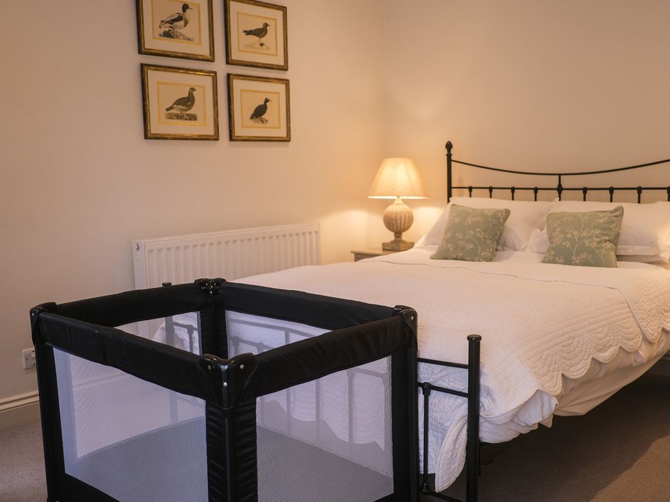 A bedroom with a bed and crib at Oaters Wood in Petworth