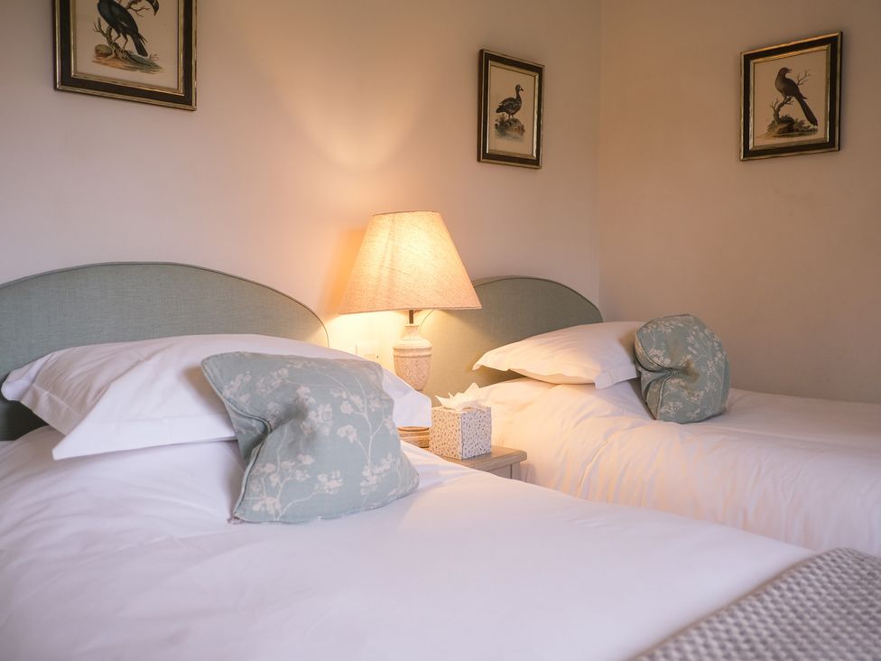 A bedroom with two beds and a lamp at Oaters Wood in Petworth