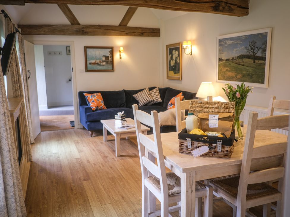 A living room with a sofa and dining table at Heathe End Lodsworth near Eastbourne