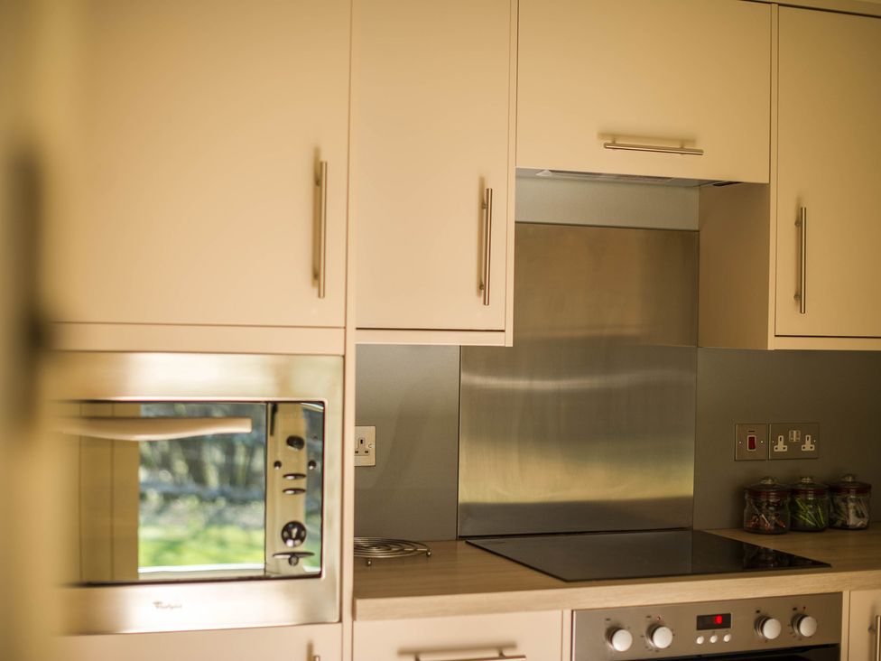 A kitchen with a microwave and electric hob at Heathe End in Lodsworth near Eastbourne