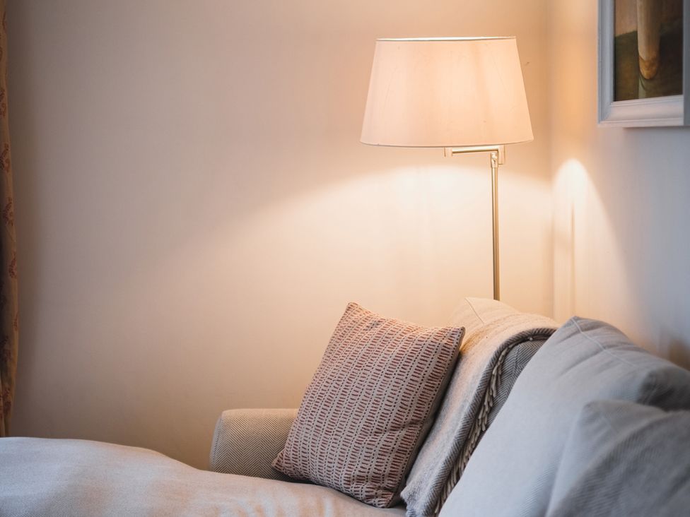 A couch with a pillow and lamp at High Field in Petworth