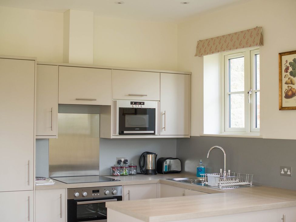 A kitchen with appliances and cabinetry at High Field in Petworth