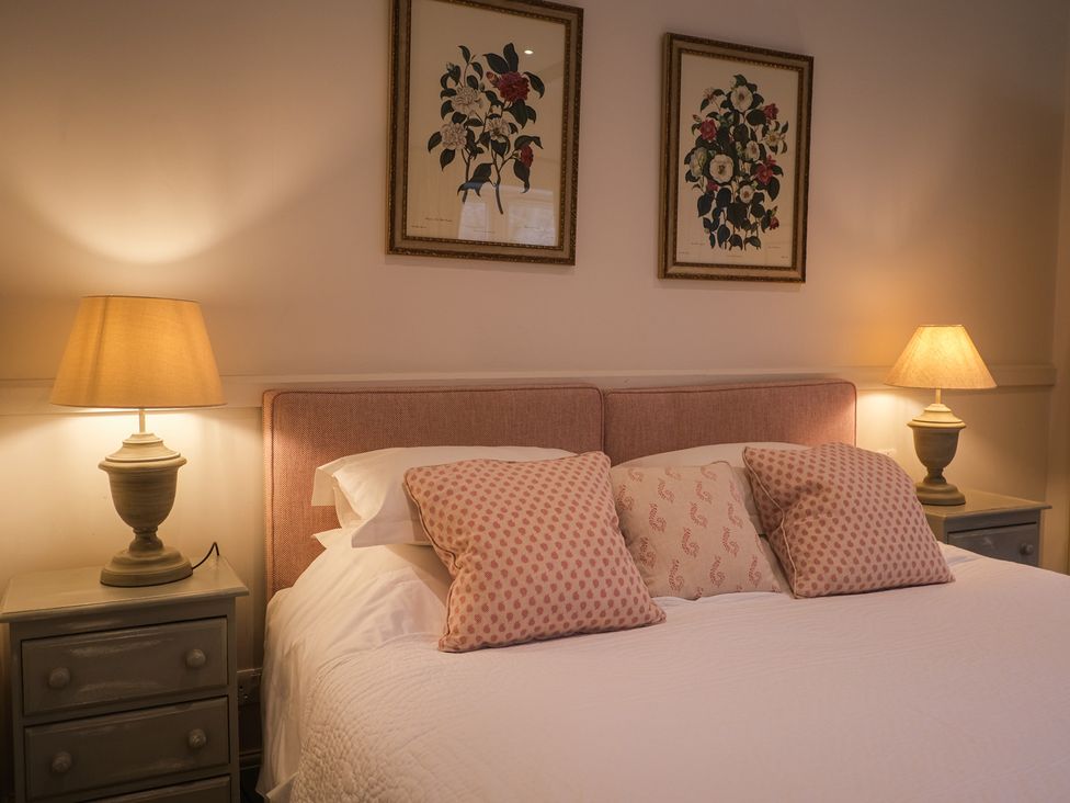 A bedroom with a bed and lamps at High Field in Petworth