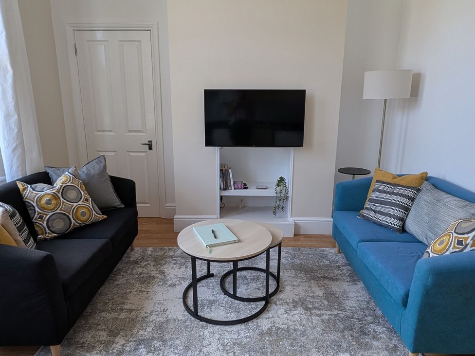 A living room with a coffee table and television at Flat 3 in Poole