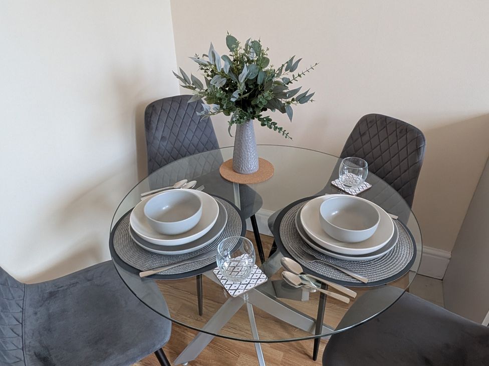 A dining table set with plates and glassware at Flat 3 in Poole