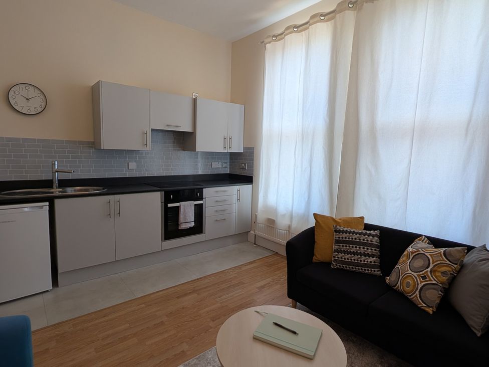 A kitchen with a sofa and coffee table at Flat 3 Poole