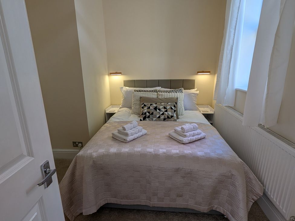A bedroom with a bed and towels arranged at Flat 3 in Poole