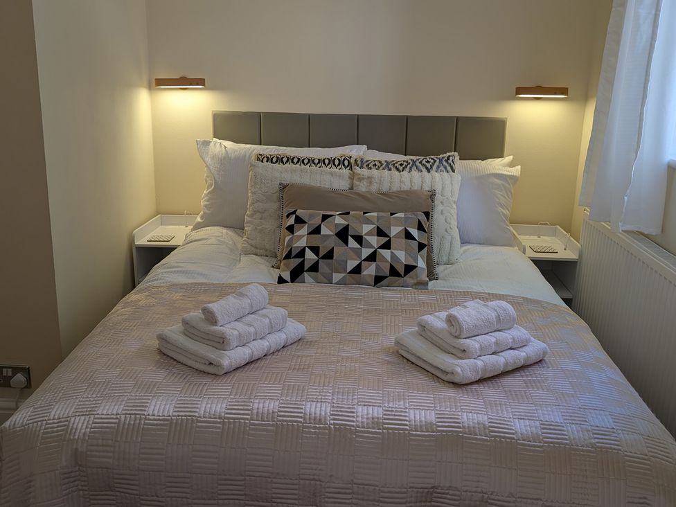 A bedroom with a bed and towels arranged at Flat 3 in Poole
