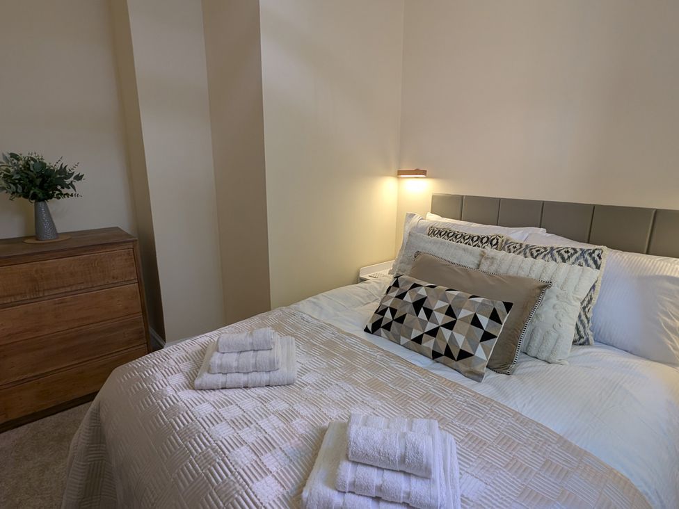 A bedroom with a bed and dresser at Flat 3 in Poole