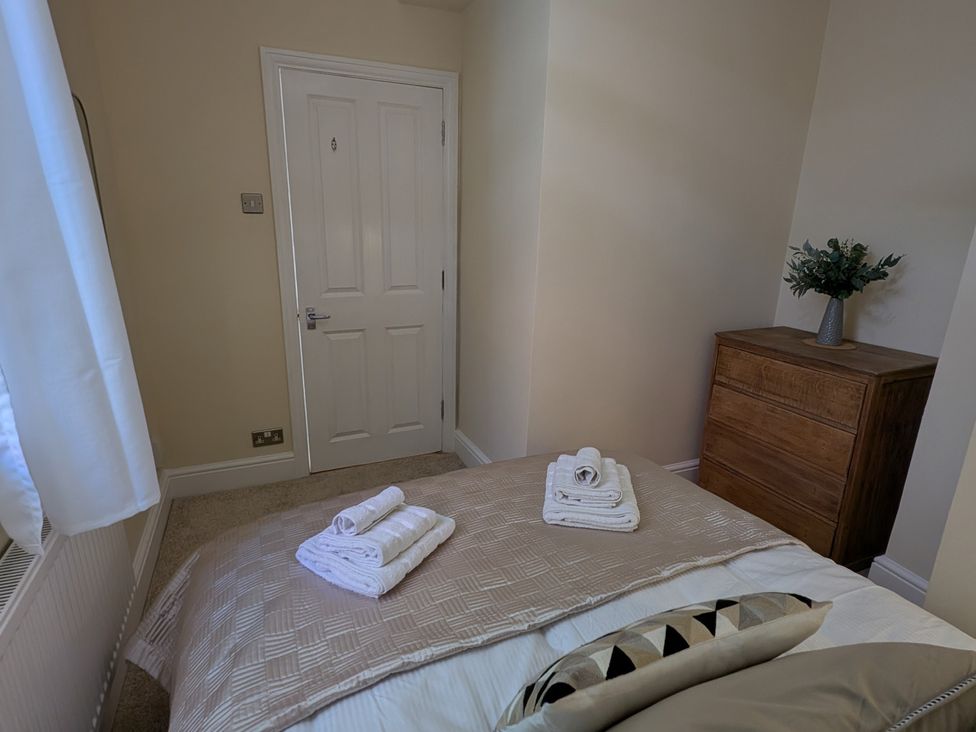 A bedroom with a bed and towels on it at Flat 3 in Poole