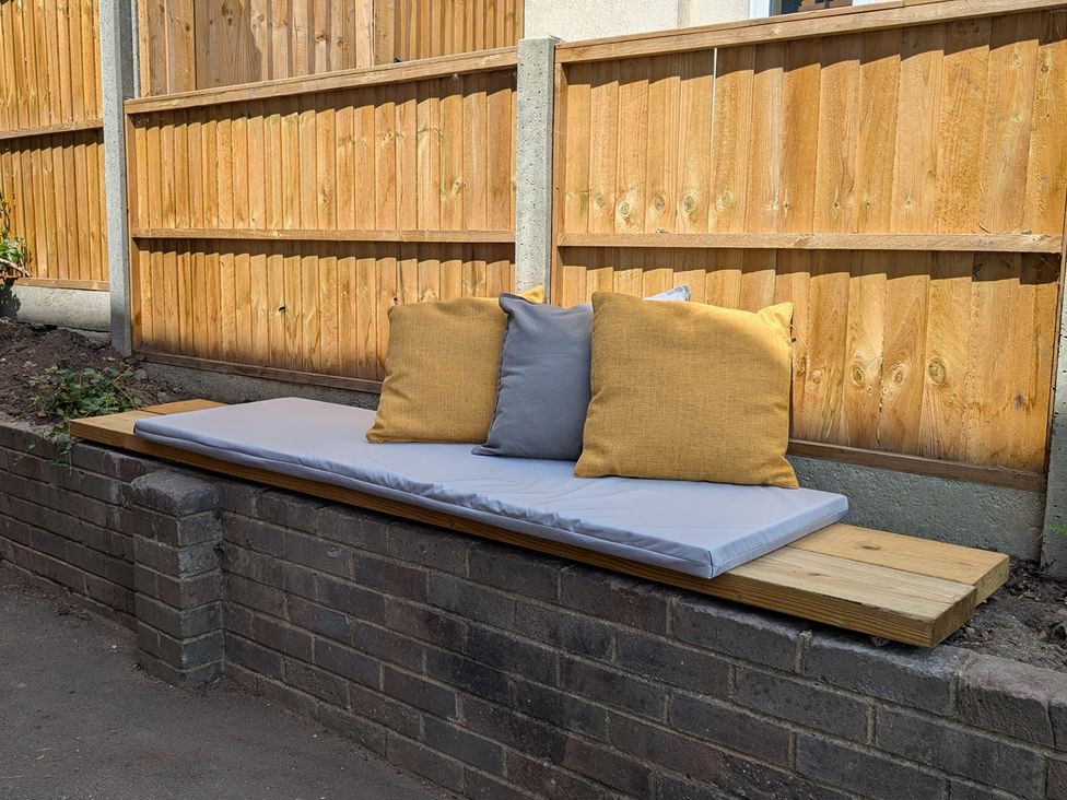 A bench with cushions in an outdoor seating area at Flat 3 in Poole