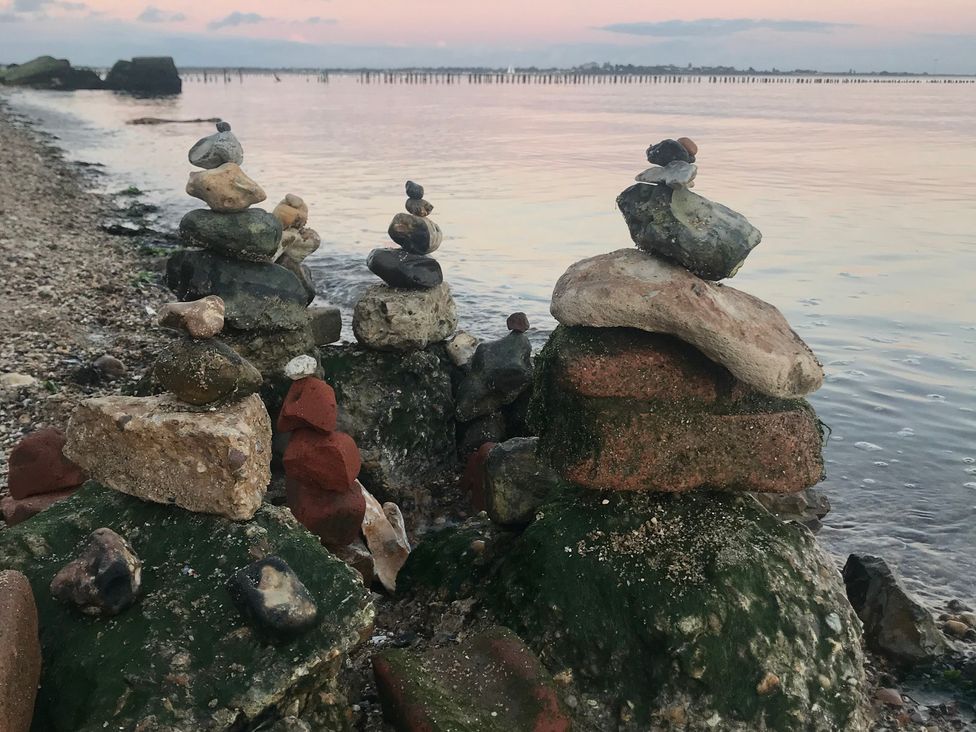 Stacked stones at the shoreline at Oakwood Annexe in Colchester