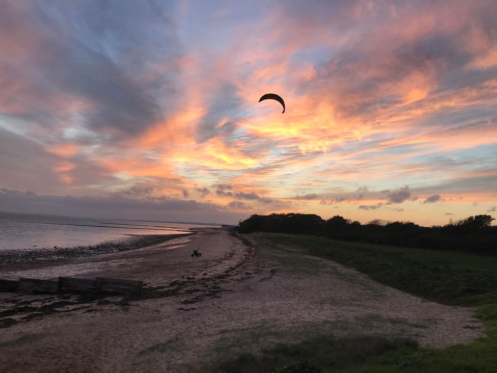 A beach with a kite in the sky at Oakwood Annexe in Colchester