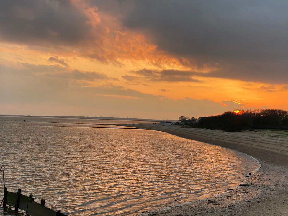 A beach at sunset with water and sand at Oakwood Annexe in Colchester