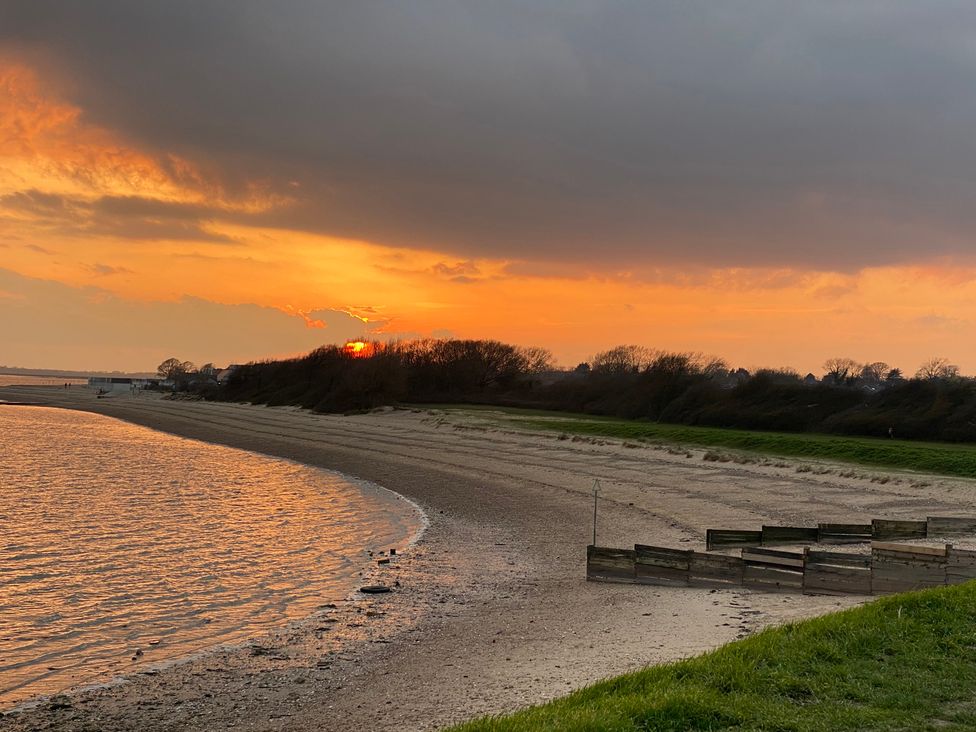 A sunset over a river with sand and grass at Oakwood Annexe in Colchester