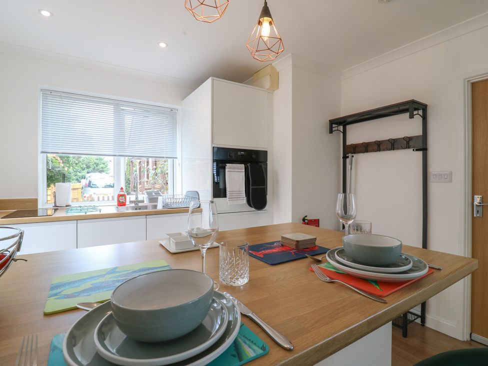 A kitchen with dining table and dinnerware at Oakwood Annexe in Colchester