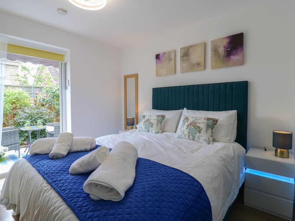 A bedroom with a bed and a bedside table at Oakwood Annexe in Colchester