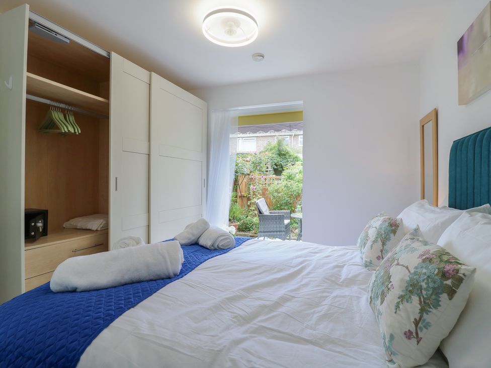 A bedroom with a bed and wardrobe at Oakwood Annexe in Colchester