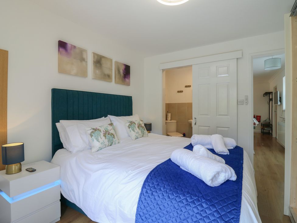 A bedroom with a bed and bedside table at Oakwood Annexe Colchester