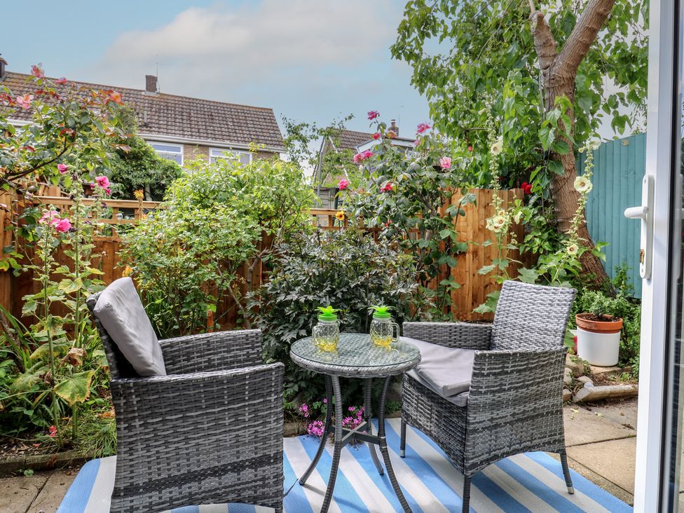 A garden with chairs and a table surrounded by plants at Oakwood Annexe in Colchester