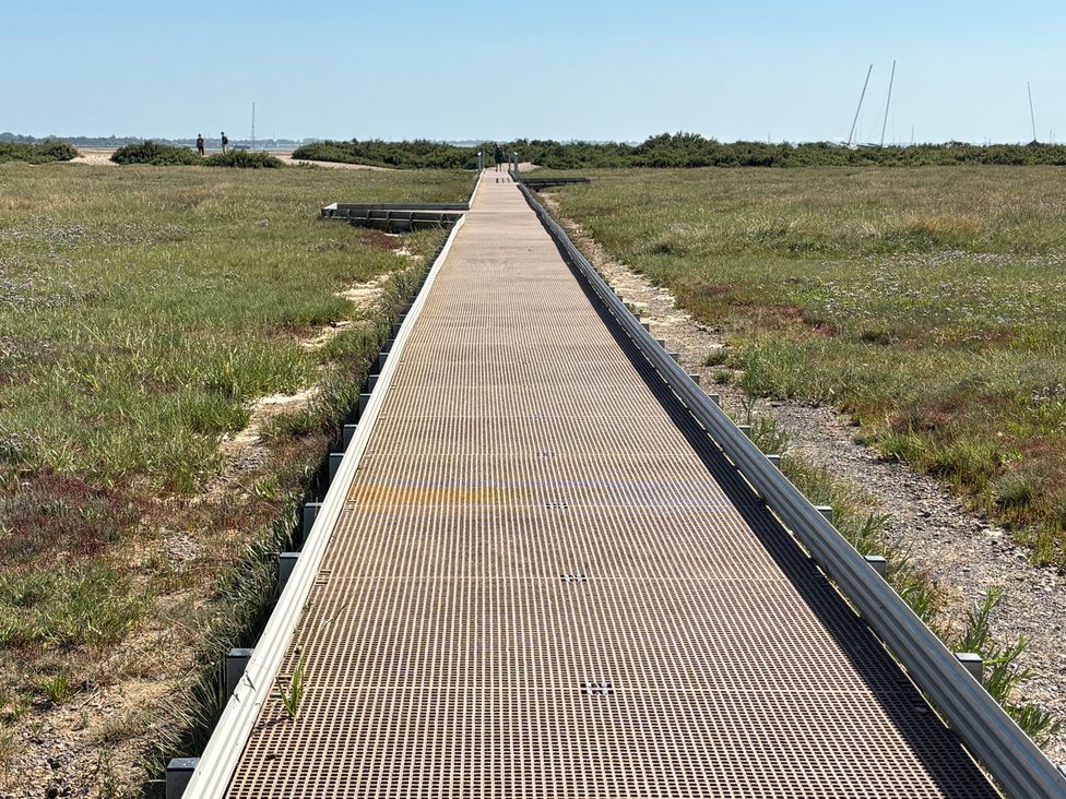 A pathway leading through grass with people in the distance at Oakwood Annexe, Colchester