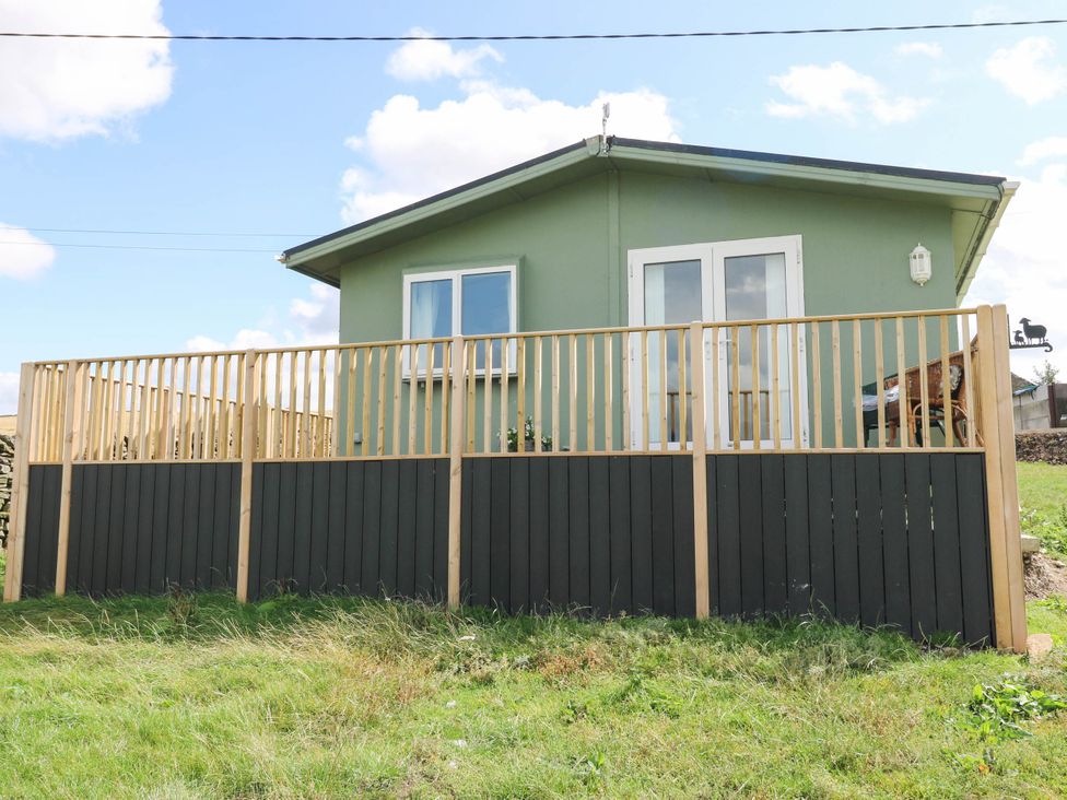 A house with a wooden fence and windows at Lodge in High Peak