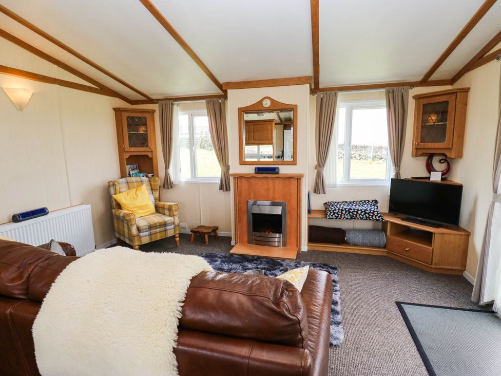 A living room with a sofa and television at Lodge in High Peak