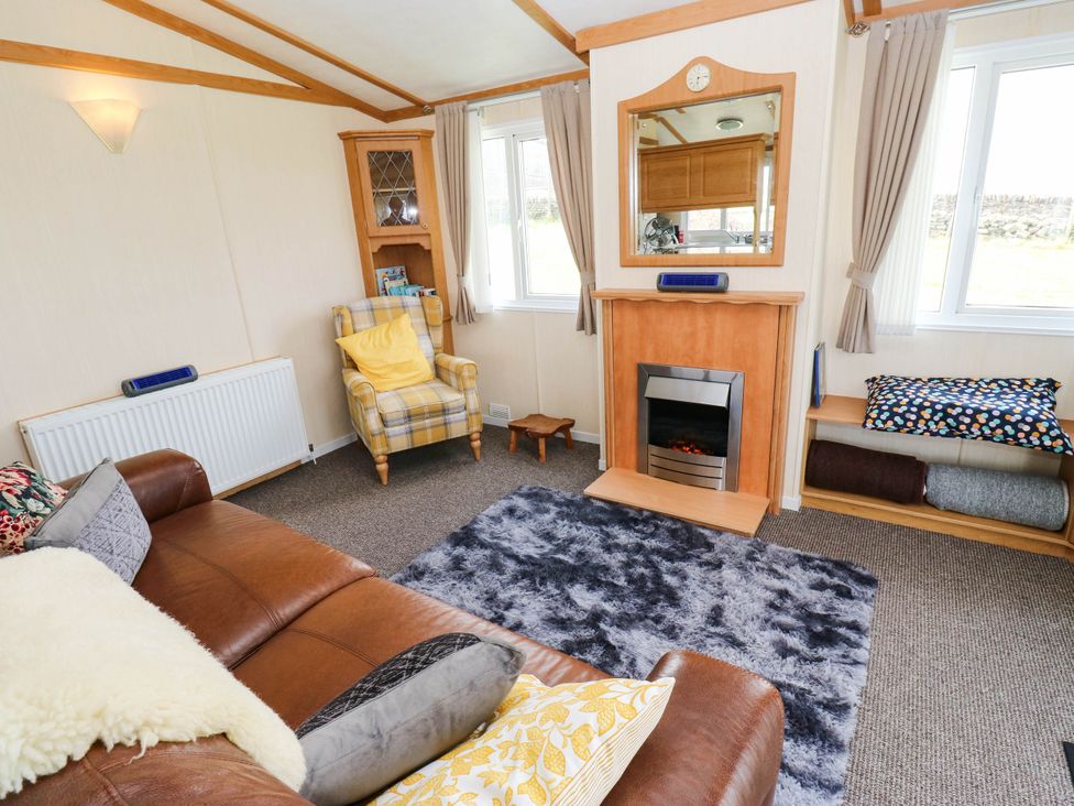 A living room with a fireplace and sofa at Lodge in High Peak
