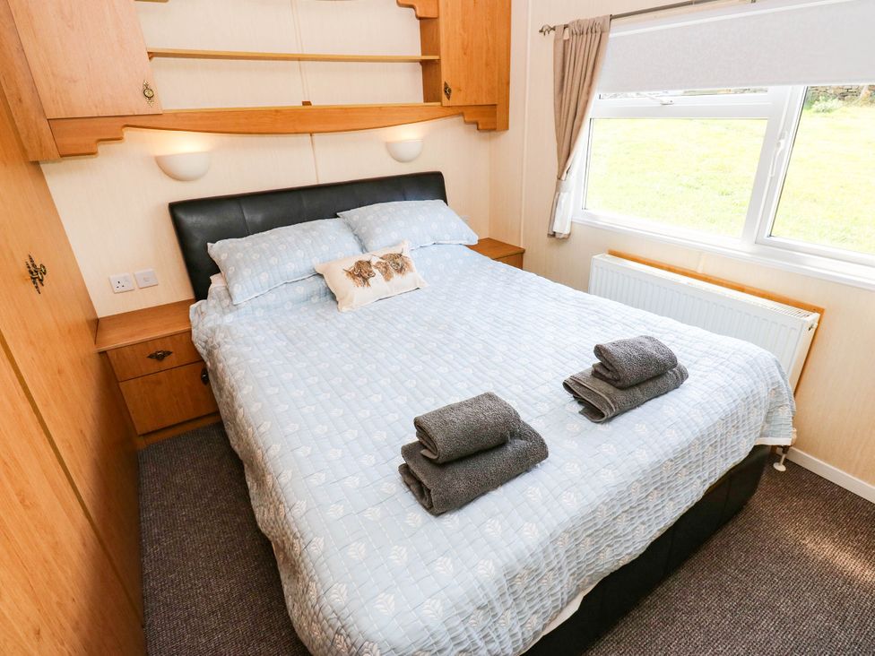 A bedroom with a double bed and towels on it at Lodge in High Peak