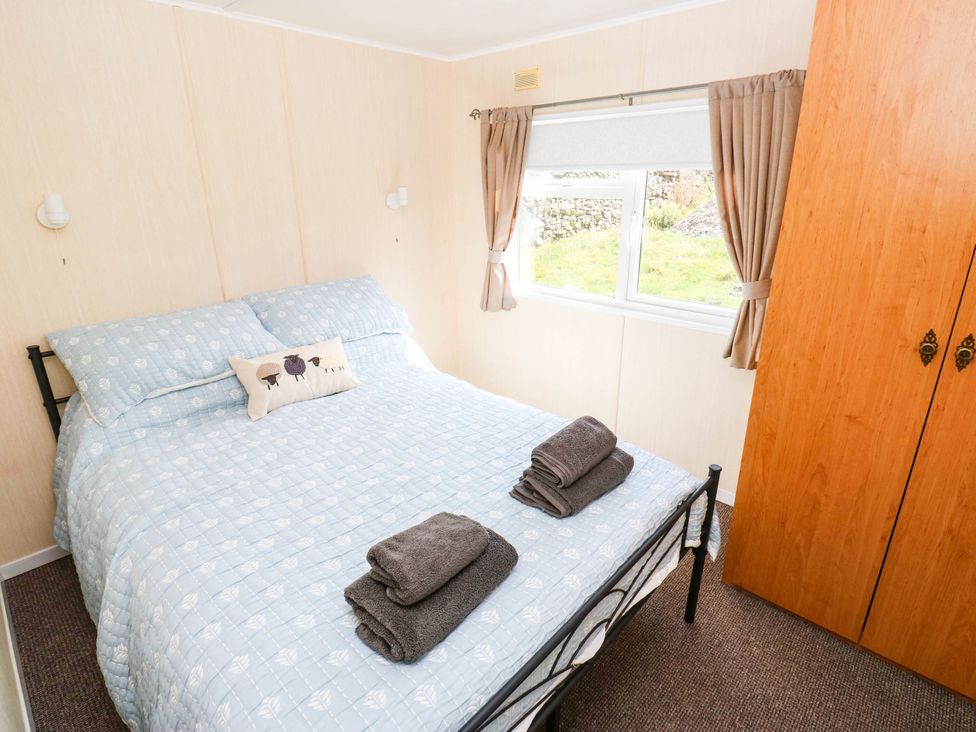A bedroom with a bed and wardrobe at Lodge in High Peak