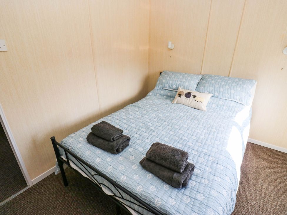 A bedroom with a bed and towels at the Lodge in High Peak
