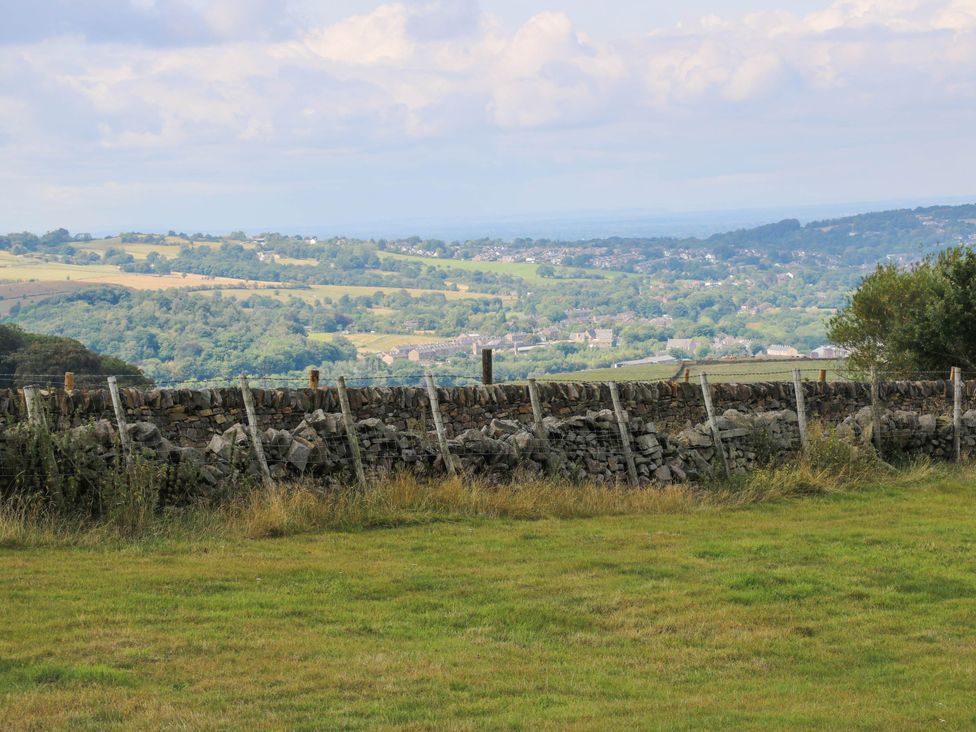 A view of a stone wall and hills from a field at Lodge in High Peak