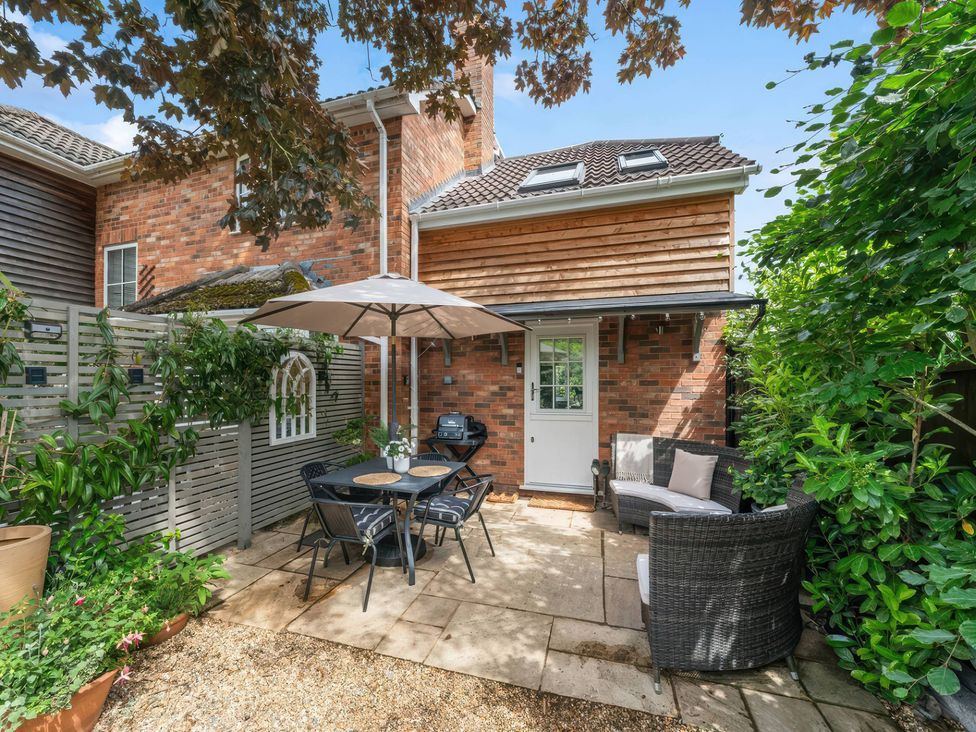 An outdoor patio with a table and chairs under an umbrella at TBC in 