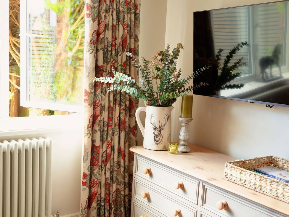 A living room with a vase and a candle on a table at TBC