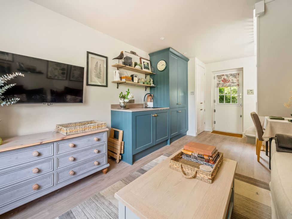 A living room with a kitchen area and a television at TBC