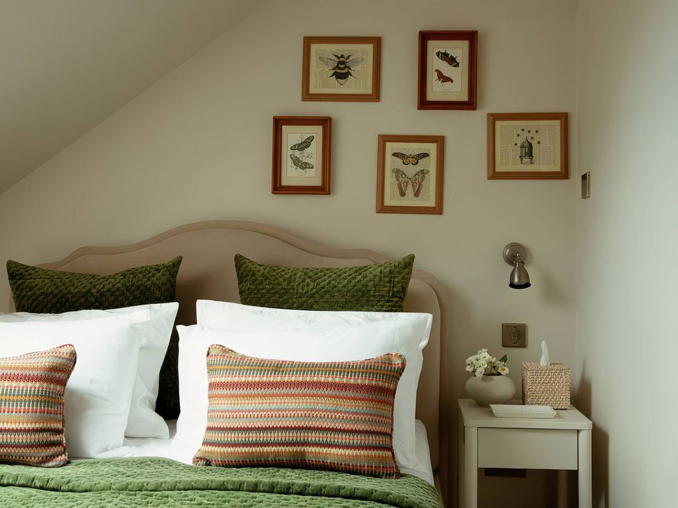 A bedroom with a bed and wall art at TBC
