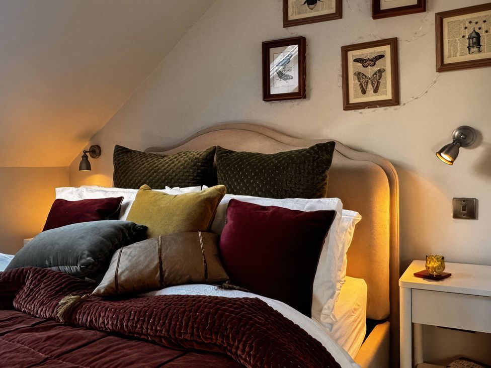 A bedroom with a bed and pillows at TBC