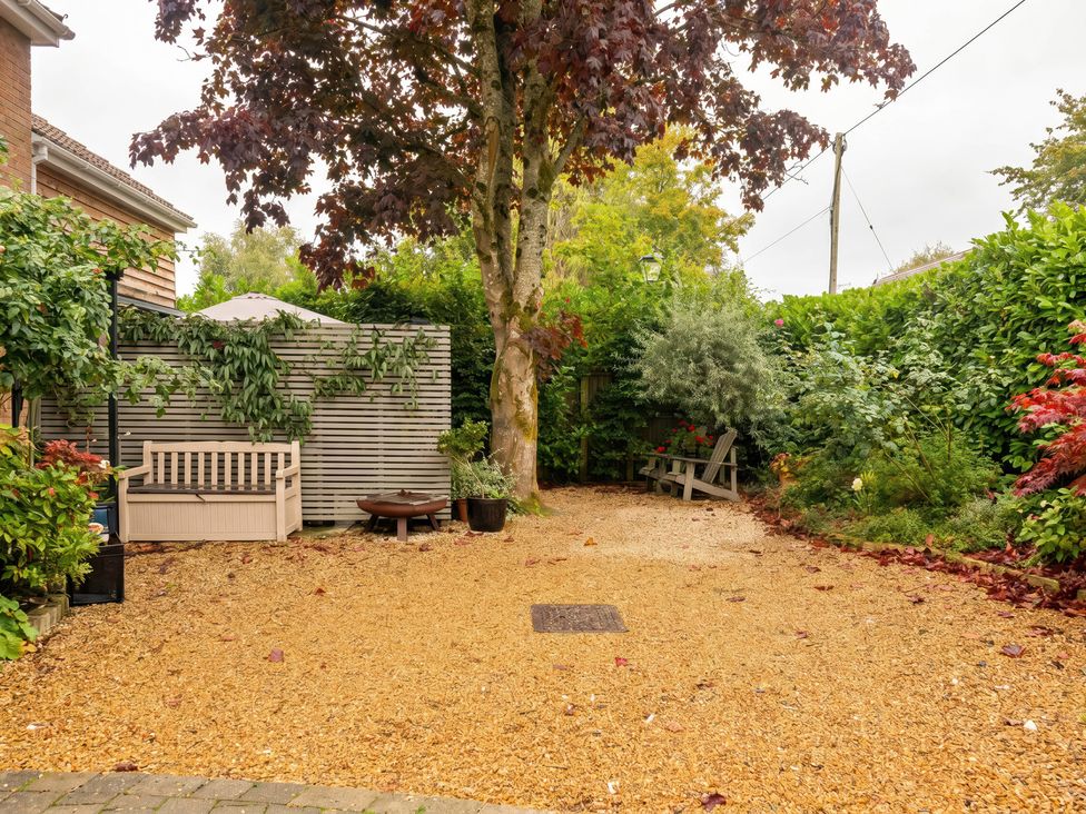 A garden with gravel path and seating at TBC
